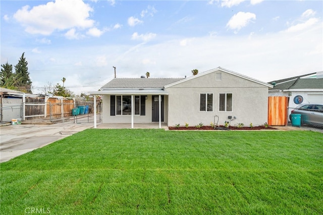 view of front of home featuring a front lawn, a patio area, fence, and stucco siding