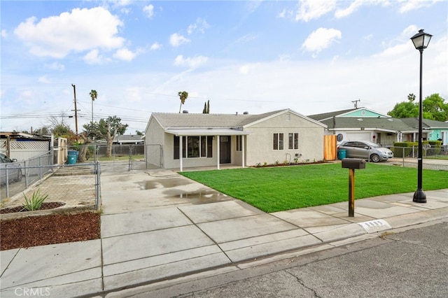 view of front of home with driveway, stucco siding, fence, and a front yard