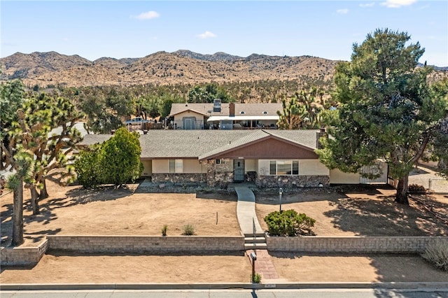 view of front of home with stone siding and a mountain view