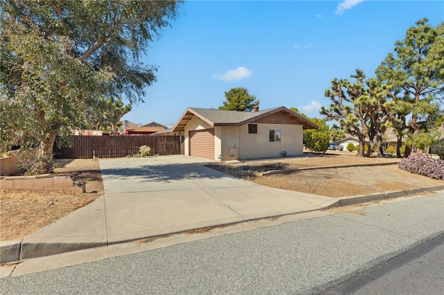 single story home with driveway, fence, and stucco siding