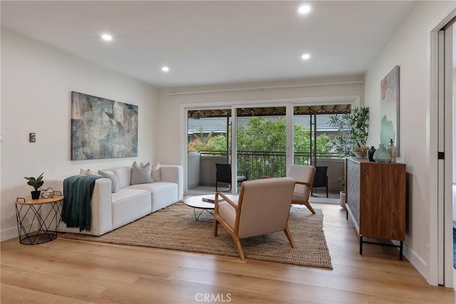 living room with baseboards, light wood-type flooring, and recessed lighting