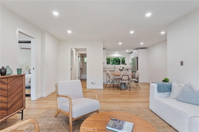 living room featuring light wood-style floors, recessed lighting, and baseboards