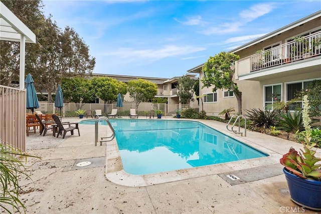 pool featuring fence and a patio