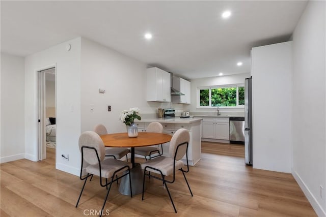 dining room with light wood-style floors, baseboards, and recessed lighting