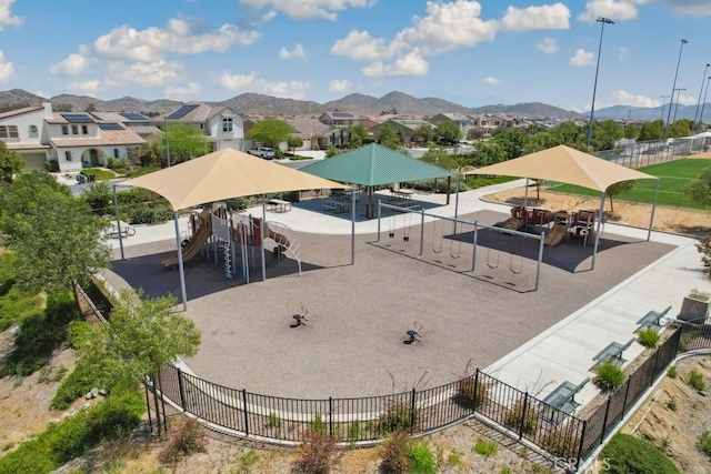 view of community featuring a mountain view, a residential view, playground community, and fence