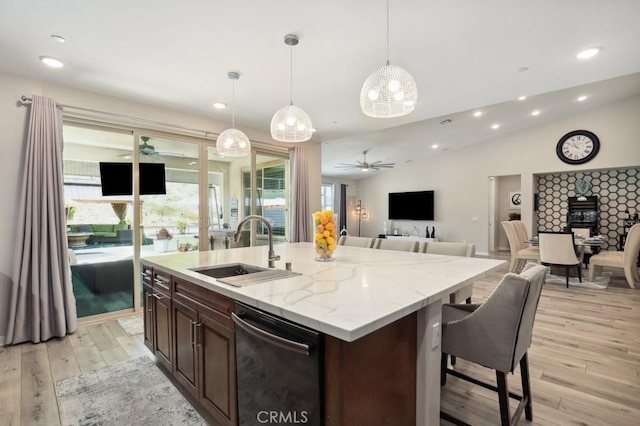 kitchen with light wood-style flooring, a ceiling fan, open floor plan, and a sink