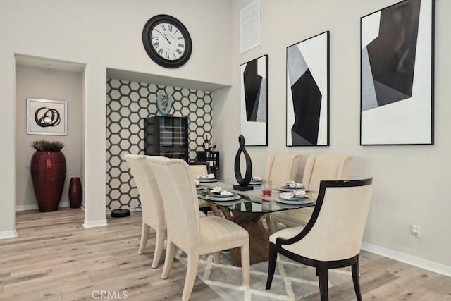 dining room featuring baseboards and light wood-type flooring