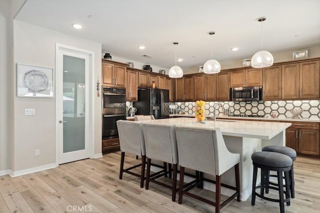 kitchen featuring decorative backsplash, stainless steel microwave, light wood-style floors, and black refrigerator with ice dispenser