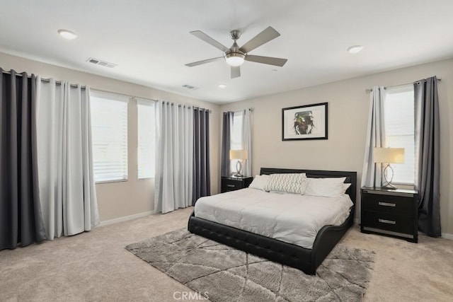 bedroom with visible vents, light colored carpet, and baseboards