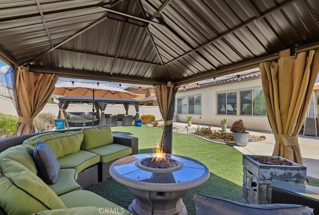 view of patio / terrace featuring a gazebo, an outdoor living space with a fire pit, and fence