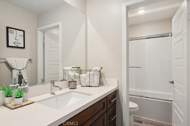 full bathroom with vanity, toilet, wood finished floors, and enclosed tub / shower combo