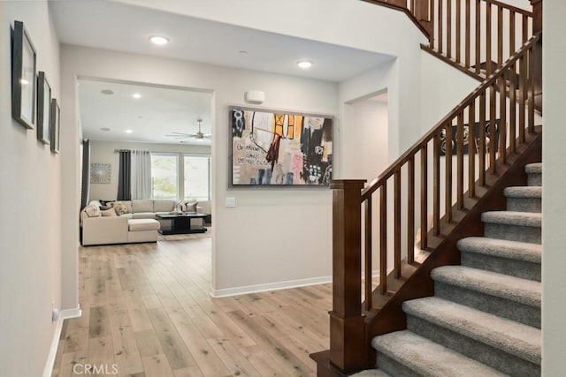 staircase featuring recessed lighting, a ceiling fan, baseboards, and wood-type flooring