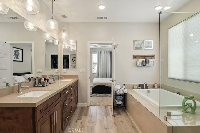 full bathroom featuring a sink, visible vents, connected bathroom, and wood finished floors