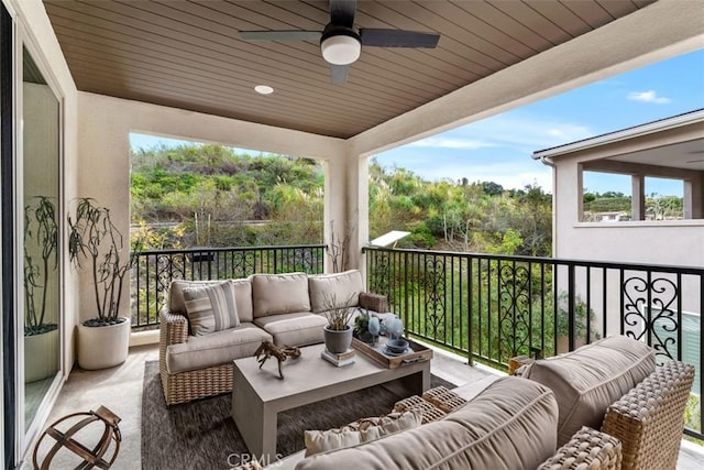 balcony featuring a sunroom, an outdoor living space, and a ceiling fan