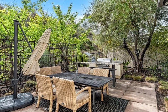 view of patio with outdoor dining area, a fenced backyard, and a grill