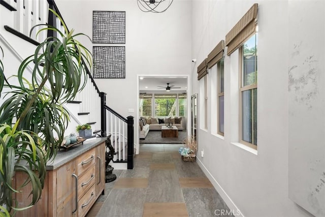 entryway featuring a high ceiling, stairway, and baseboards