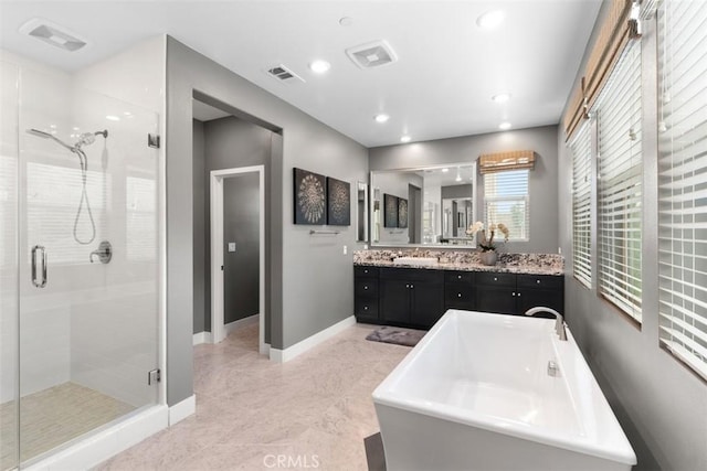 bathroom with recessed lighting, a soaking tub, a stall shower, vanity, and baseboards