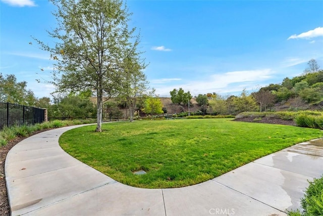 view of home's community featuring a yard and fence