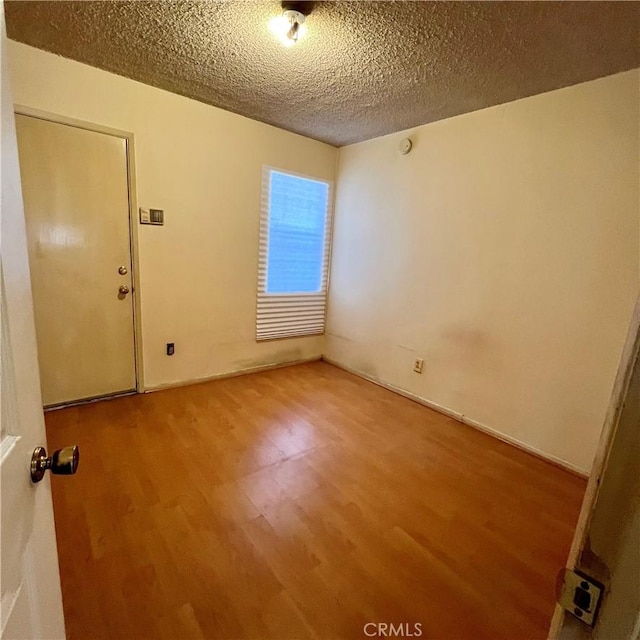 empty room featuring a textured ceiling and wood finished floors