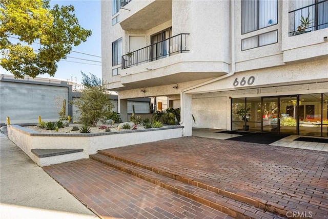 view of exterior entry featuring stucco siding