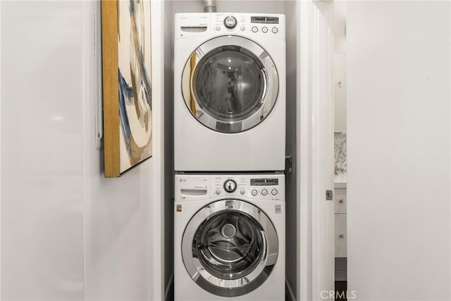 clothes washing area featuring laundry area and stacked washer and clothes dryer