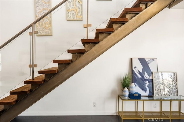 stairs featuring wood finished floors and baseboards