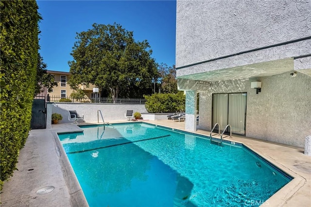 pool with fence and a patio area