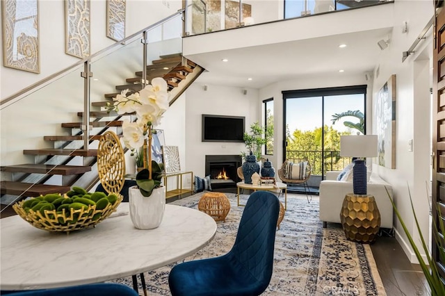 660 N Sweetzer Ave Unit 302, West Hollywood, CA 90048 - living room with stairs, wood finished floors, a high ceiling, a lit fireplace, and recessed lighting