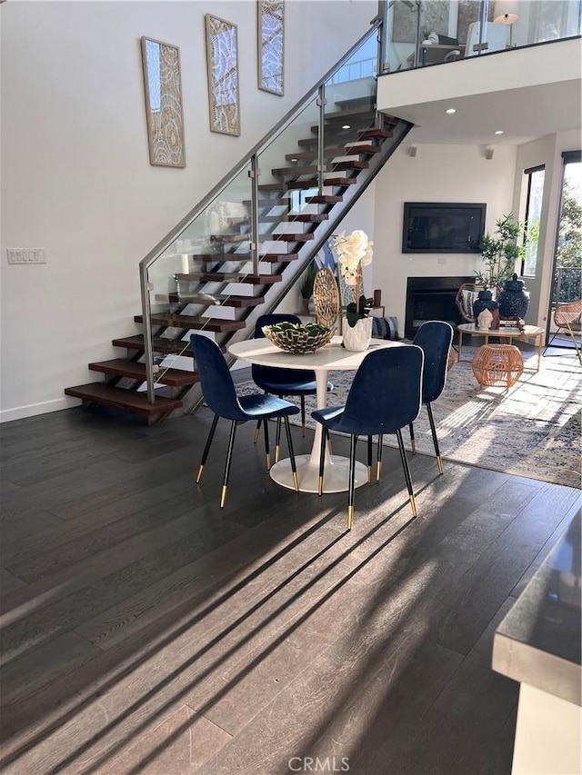 660 N Sweetzer Ave Unit 302, West Hollywood, CA 90048 - dining room with stairway, wood finished floors, a fireplace, and a high ceiling