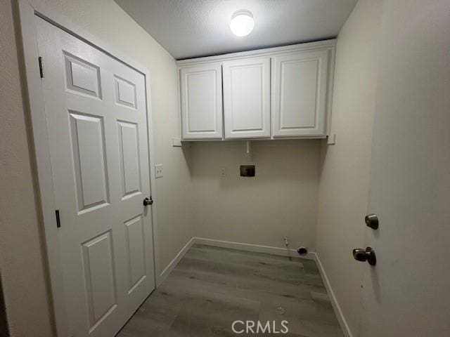 laundry room with cabinet space, hookup for a washing machine, baseboards, and wood finished floors