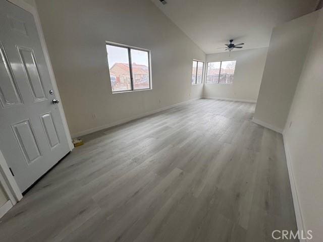 unfurnished room with high vaulted ceiling, a ceiling fan, baseboards, and wood finished floors