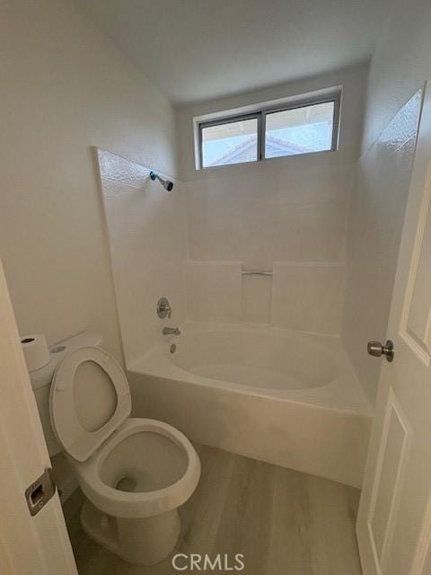 bathroom with toilet, washtub / shower combination, and wood finished floors