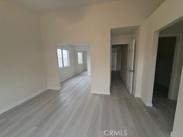 empty room with baseboards and wood finished floors