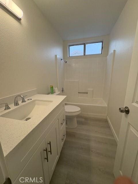 bathroom with toilet, a wall unit AC, shower / tub combination, wood finished floors, and vanity