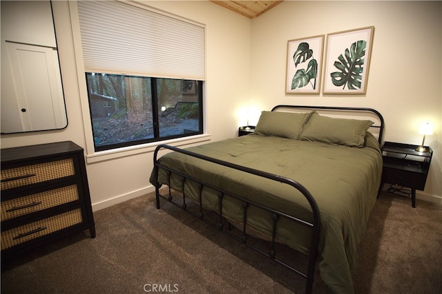 bedroom with carpet, baseboards, and vaulted ceiling