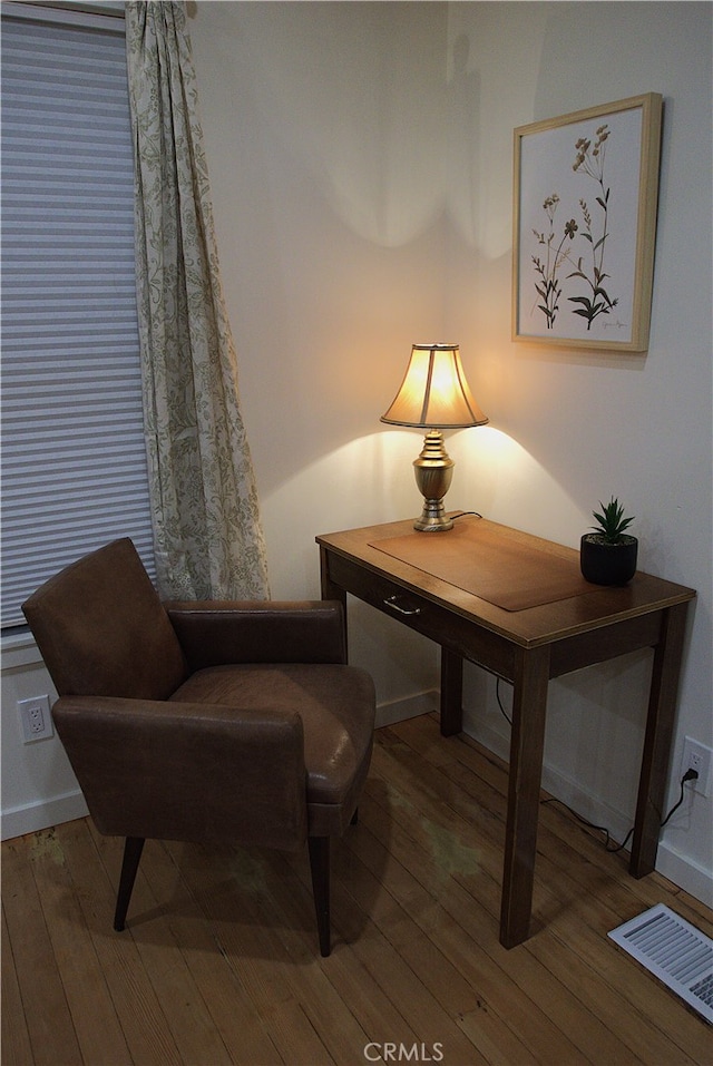 sitting room with hardwood / wood-style flooring, visible vents, and baseboards