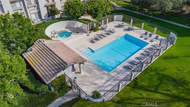 community pool with a patio area and fence