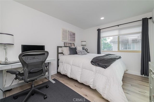 bedroom with baseboards, wood finished floors, and recessed lighting