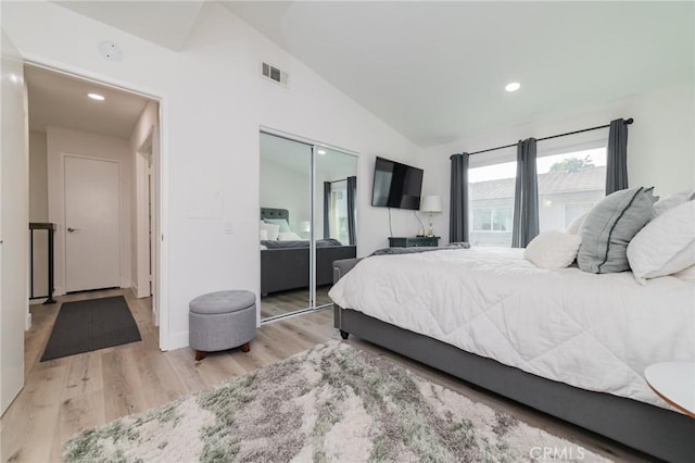 bedroom with lofted ceiling, a closet, wood finished floors, and recessed lighting