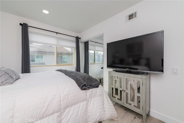 bedroom featuring baseboards, wood finished floors, visible vents, and recessed lighting