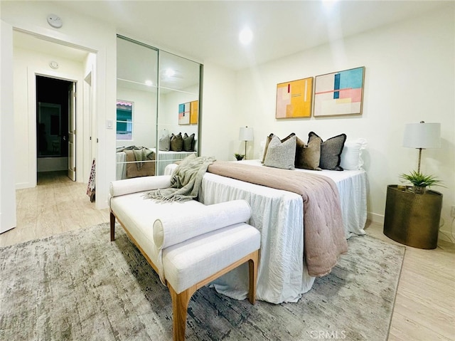 bedroom with wood finished floors and a closet