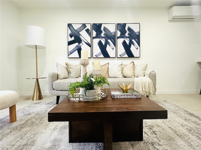 living room featuring wood finished floors, baseboards, and a wall mounted AC