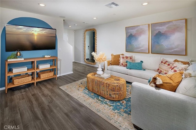 living room with recessed lighting, visible vents, baseboards, and wood finished floors