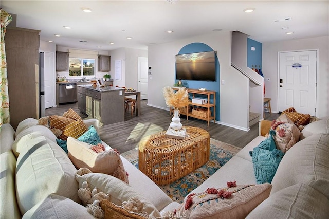 living room with dark wood-type flooring, recessed lighting, stairway, and baseboards