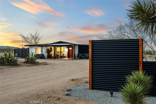 56622 Handley Rd, Yucca Valley, CA 92284 - outdoor structure at dusk featuring covered porch and driveway