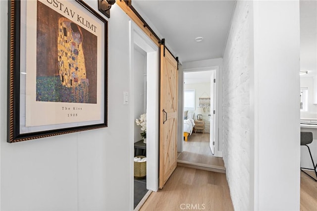 56622 Handley Rd, Yucca Valley, CA 92284 - hallway with a barn door and light wood-style flooring