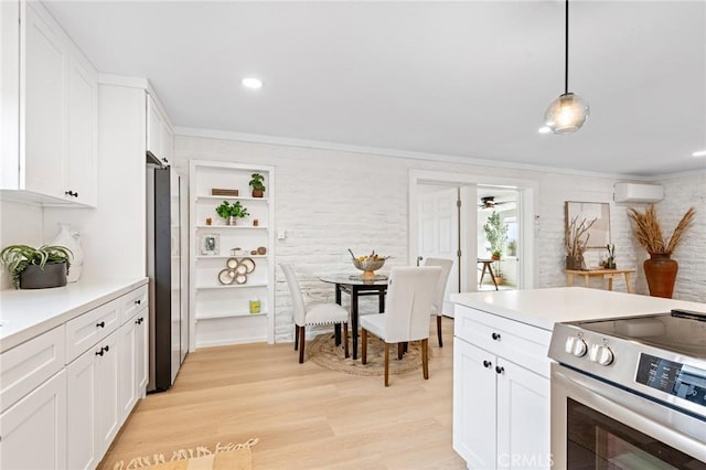 56622 Handley Rd, Yucca Valley, CA 92284 - kitchen featuring appliances with stainless steel finishes, a wall mounted AC, white cabinets, ornamental molding, and light wood-type flooring