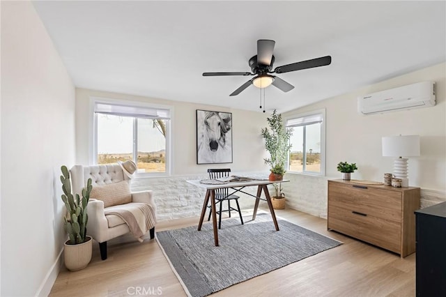 office featuring ceiling fan, plenty of natural light, light wood-style flooring, and a wall mounted air conditioner