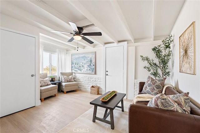 living room with light wood-style floors, ceiling fan, and beam ceiling