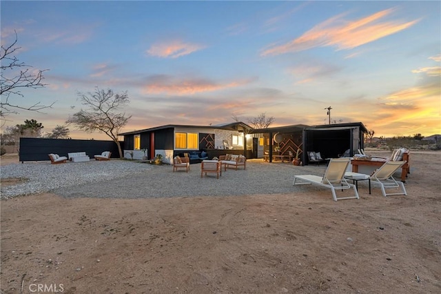 56622 Handley Rd, Yucca Valley, CA 92284 - back of property at dusk featuring an outdoor hangout area and a patio area